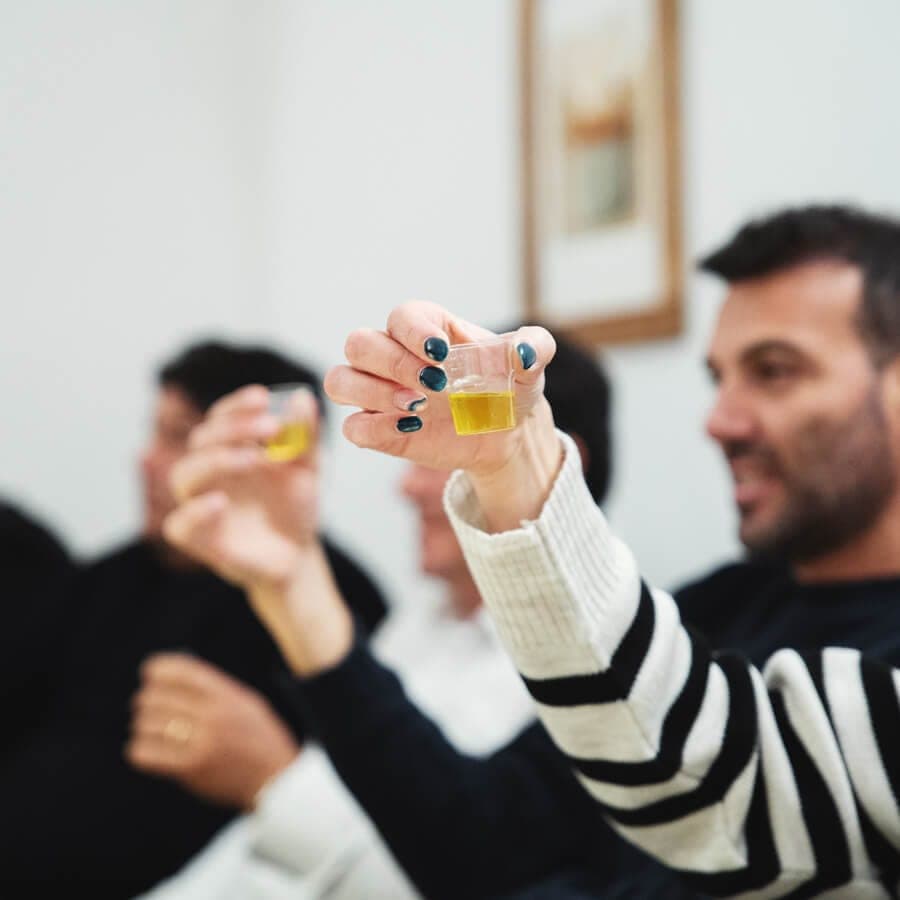Un ospite alza il bicchierino con l'olio durante l'analisi sensoriale dell'Olio EVO