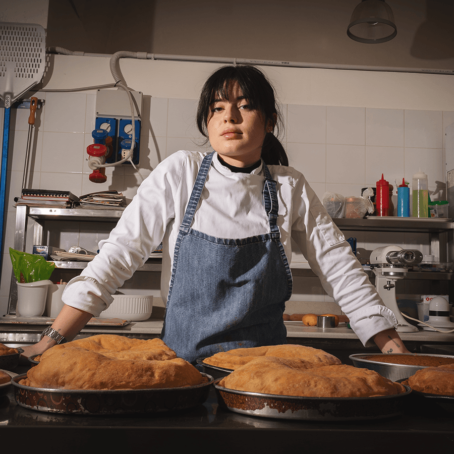 Giulia Seccia di Mistella Vino Pizza e Cucina in cucina, davanti alle teglie di pizza