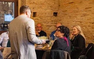Un confronto attivo e partecipato: un uomo parla agli ospiti seduti al tavolo