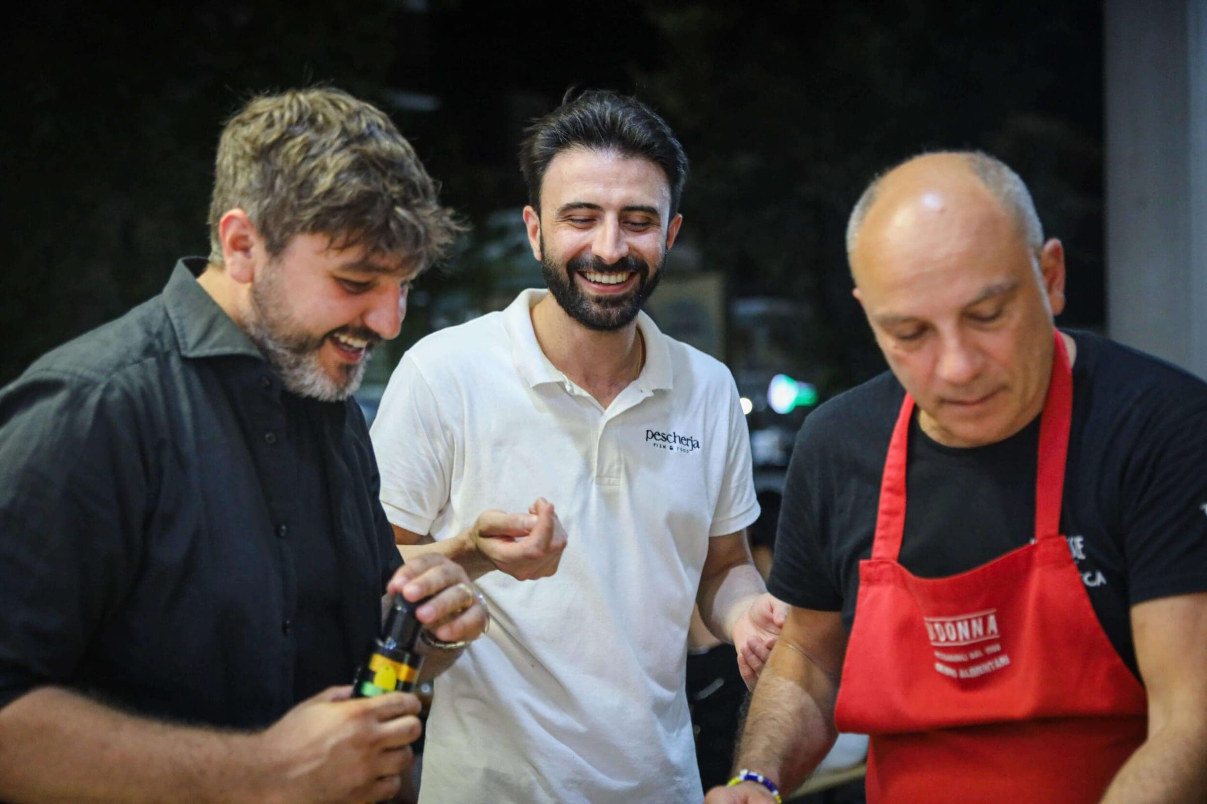 Pescherja, Cerignola: tre uomini sorridenti, uno con il grembiule rosso